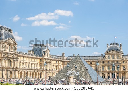 PARIS - JULY 21: The Louvre museum and the pyramid on July 21, 2013 in Paris, France. The Louvre was once a palace and is now a museum. The pyramid serves as an entrance to the museum.