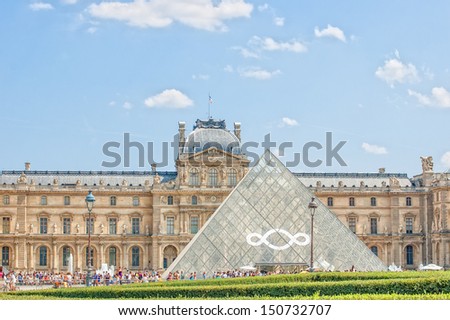 PARIS - JULY 21: The Louvre museum and the pyramid on July 21, 2013 in Paris, France. The Louvre was once a palace and is now a museum. The pyramid serves as an entrance to the museum.