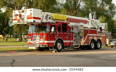 A picture of a fire truck on a residential street in the late evening sun