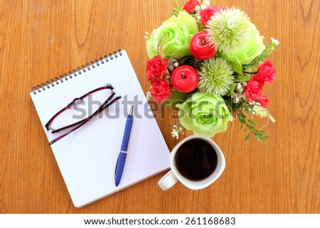 note book and office tools on the wood table with black coffee