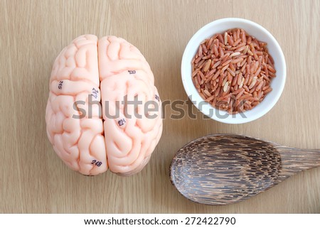 brain and red rice on wooden background with healthy concept