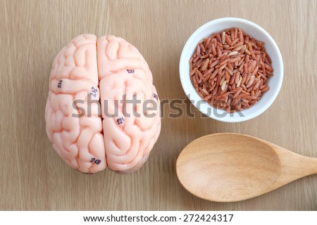 brain and red rice on wooden background with healthy concept