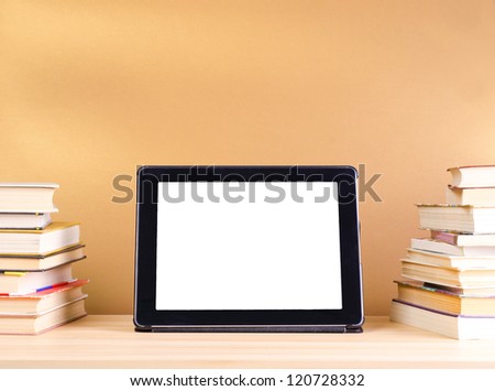 tablet pc and stack book on wooden table