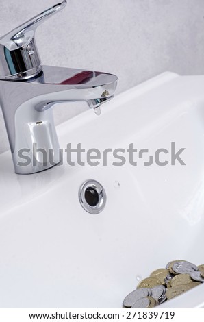 wash basin and running water from the tap in chrome bathroom, water saving concept