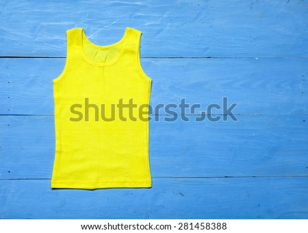 bright knitted T-shirt on blue wooden background