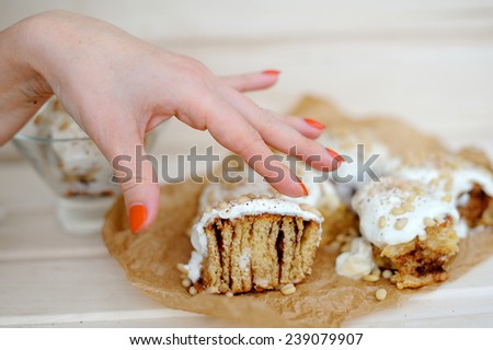 woman hand touching bun with cream and nuts