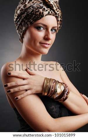 A beautiful arabian blonde woman posing in a studio wearing jewelry.