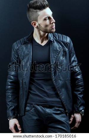 young handsome man. Studio fashion portrait. Posing over black background.Fashion colors.