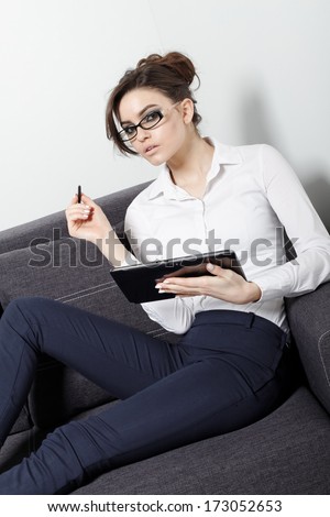 Businesswomen sitting on couch with digital tablet and studying at home