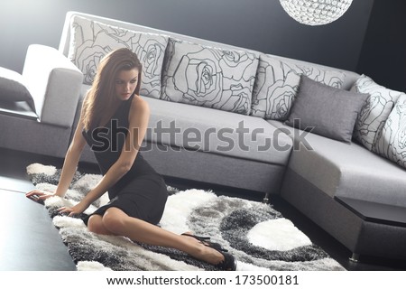 Beautiful young woman in living room on sofa .Fashion light and colors.