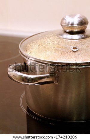 new stainless steel saucepans on modern kitchen range