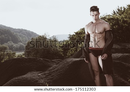 Outdoor natural portrait of a gorgeous male fitness model.Fashion colors.Wide angle.