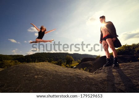 Outdoor natural portrait of a gorgeous couple fitness models.Gymnastics girl.Fashion colors.Wide angle .Fine art.