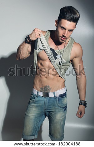 Fashion portrait of sexy male fitness model against neutral background