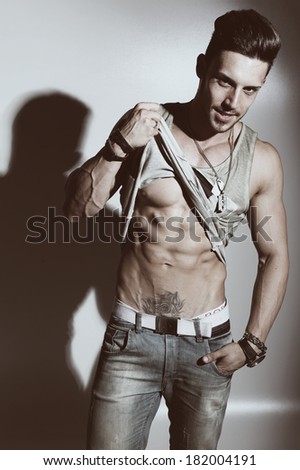 Fashion portrait of sexy male fitness model against neutral background