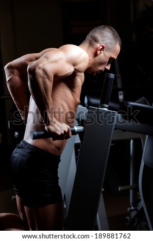 Muscled male model with strong arms.Triceps  Workout . Low light.