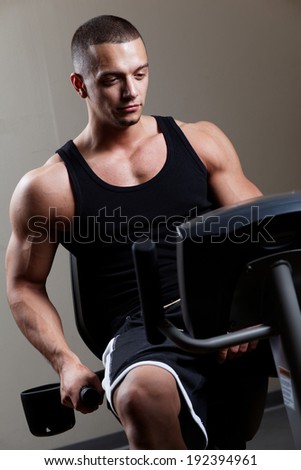 Stationary bicycles fitness man in a gym sport club .Close up.