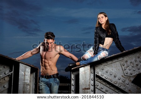 Outdoor natural portrait of a gorgeous couple fitness models.Gymnastics girl.Fashion colors.