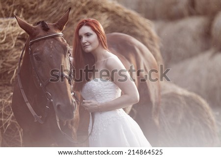 Fashionable  woman riding a horse in sunny day. Long curly hair. Fashion colors.