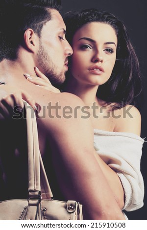 Beautiful young smiling couple in love embracing indoor.Glamour colors.No brand.