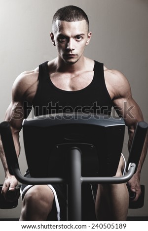 Stationary bicycles fitness man in a gym sport club .Close up.