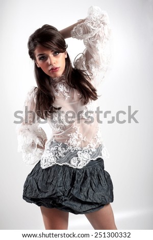 A photo of beautiful girl is in fashion style.Beautiful woman with elegant dress posing in studio. Fashion photo