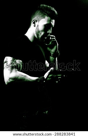 Portrait Of Young Man With Gun On Black Background, green tone