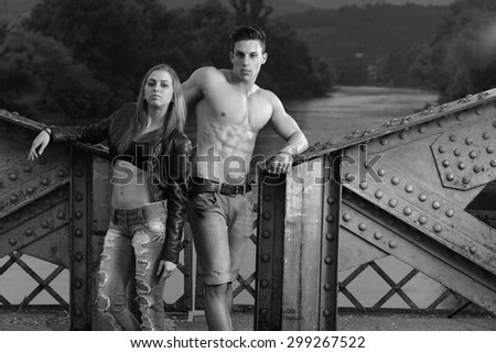 Outdoor natural portrait of a gorgeous couple fitness models. Gymnastics girl. Fashion colors.