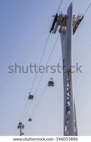 LONDON, UK - MAY 30: View of Emirates Air Line (or Thames cable car) - cable car link Greenwich Peninsula and Royal Dock across River Thames, on May 30, 2013 in London. Service opened on June 2012.