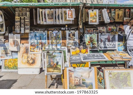 PARIS, FRANCE - MAY 18, 2014: Vintage books and pictures in open book market on embankment of river Seine near cathedral Notre Dame de. Book market on the banks of Seine is there since 16th century.