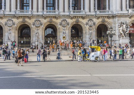 PARIS, FRANCE - MAY18, 2014: Young brass band near Paris Opera building (Garnier Palace) in Paris. Dozens buskers perform on the streets and in Paris metro.
