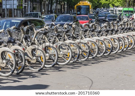 PARIS, FRANCE - MAY 18, 2014: Velib bicycles in the row on Parisian street. Velib is a large-scale public bicycle rental system in Paris.