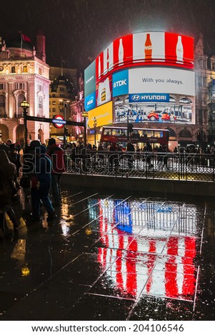 LONDON, UK - MARCH 17, 2013: Famous Piccadilly Circus neon signage shines at rainy night. These signs have become a major attraction of London, United Kingdom