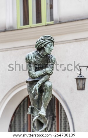 A bronze statue of a poor student near St Mary's Basilica - a replica of Wit Stwosz (German sculptor, Veit Stoss) sculptures in famous gothic altar of Basilica (Kosciol Mariacki). Kracow, Poland.