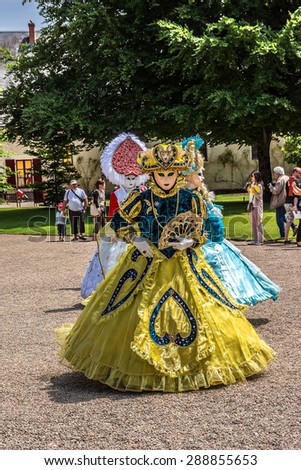 CHEVERNY, FRANCE - JUNE 10, 2015: Venetian carnival (costume party) enthusiasts, dressed in colorful costumes, masks and feathers, have animated the field of Cheverny.