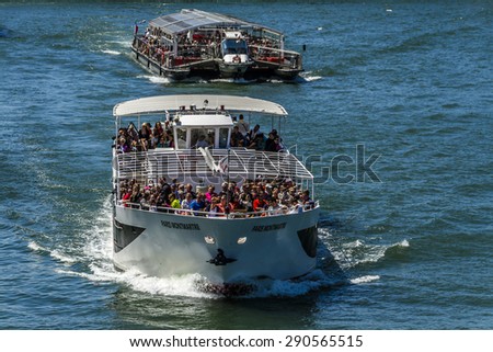 PARIS, FRANCE - JUNE 8, 2015: View of the Seine River with cruise tour boats. In Paris there are several boat tourist trips across the Seine to show tourists the sights of interest.