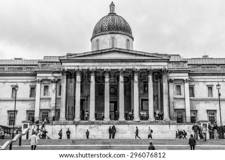 LONDON - MAY 30, 2013: Tourists visit Trafalgar Square in London. Trafalgar Square - the largest square in London, is often considered the heart of London. Black and white.