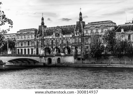 PARIS, FRANCE - MAY 30, 2015: View of famous Louvre Museum from the Seine River. Louvre Museum is one of the largest and most visited museums worldwide. Black and white.