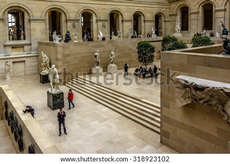 PARIS, FRANCE - DECEMBER 22, 2014: Tourists visit sculpture gallery in Louvre Museum. Louvre Museum is one of the largest and most visited museums worldwide.