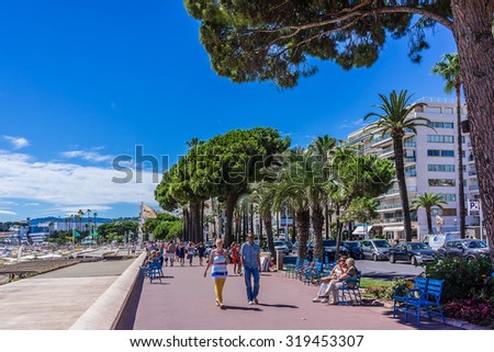 CANNES, FRANCE - JULY 7, 2014: Cannes cityscape. Cannes - a resort in southern France: many flowers and palm, luxury boutiques and restaurants, cafes, luxurious hotels - all for leisure travelers.