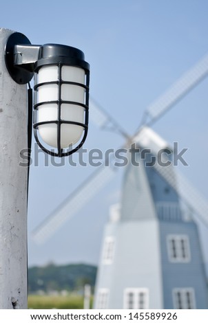 Lamp in the garden with a windmill in the background.