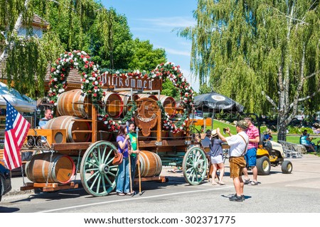 LEAVENWORTH, WA - AUG 1, 2015: Tourists having a souvenir photo taken in front of beer wagon float in Bavarian themed Cascade Mountain village of Leavenworth Washington on Aug 1, 2015.