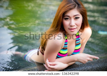 Beautiful asian woman in  bikini at pool