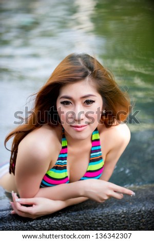 Beautiful asian woman in  bikini at pool