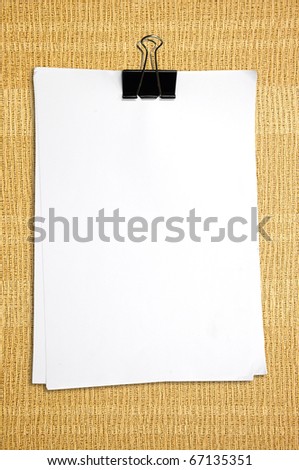 Black clip and White blank note paper on wallpaper