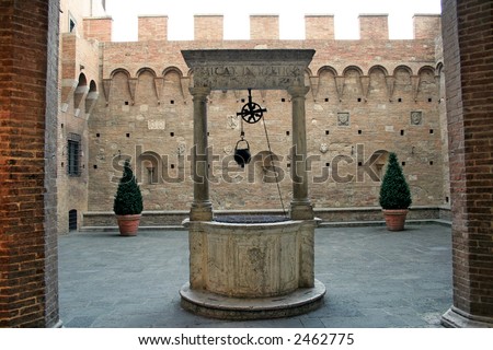 An antique water wishing well in the courtyard of a medieval palace in Siena, Italy