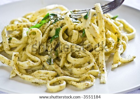 Scialatielli (spaghetti-like pasta) with pesto sauce.A typical italian dish. Picking up with a fork.