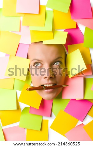Woman with many reminder notes and pen in the mouth