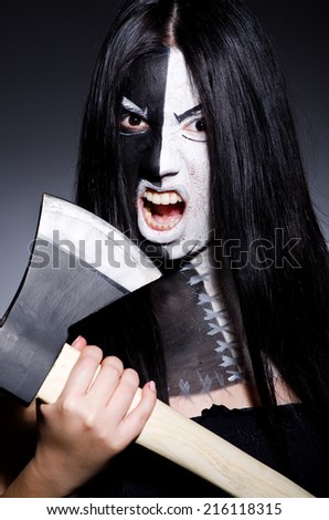 Scary woman with metal axe in halloween concept