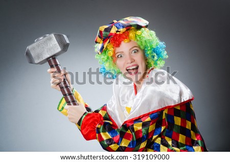 Clown with hammer in funny concept